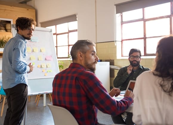 Team members collaborating around a whiteboard